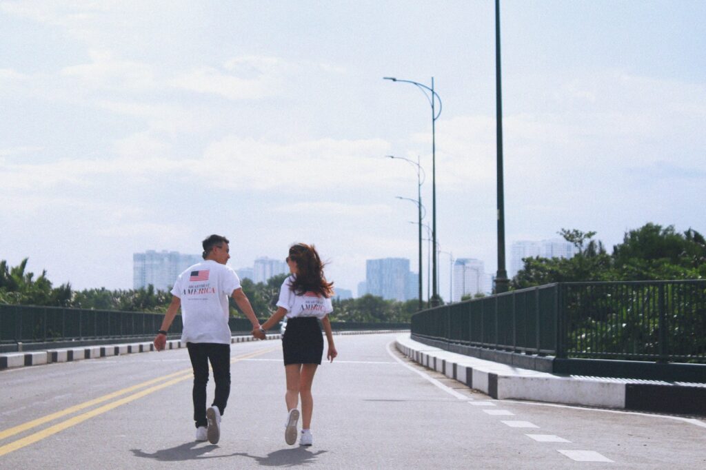 man and woman holding hands while walking on street