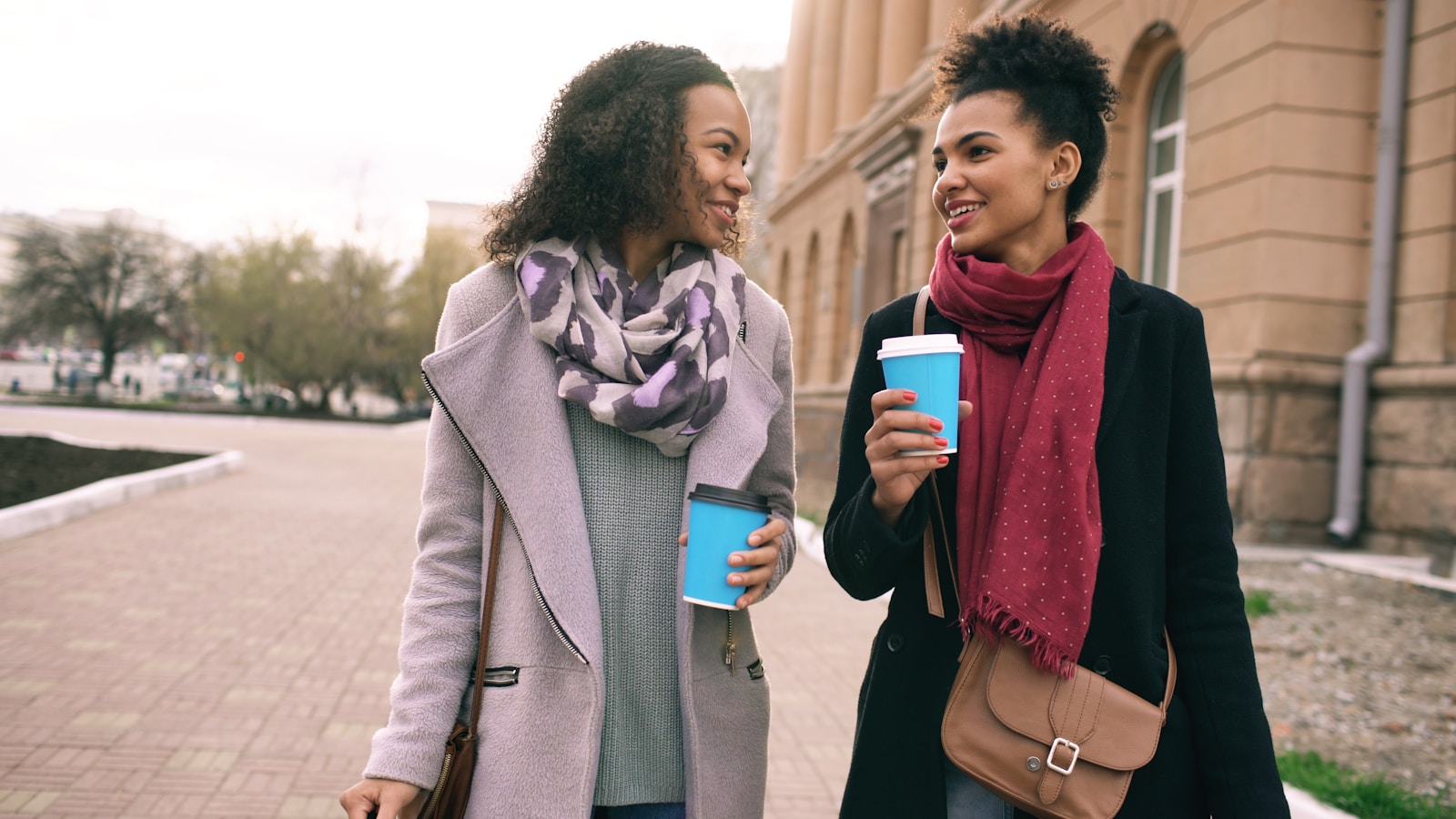 Two women walking with coffee cups